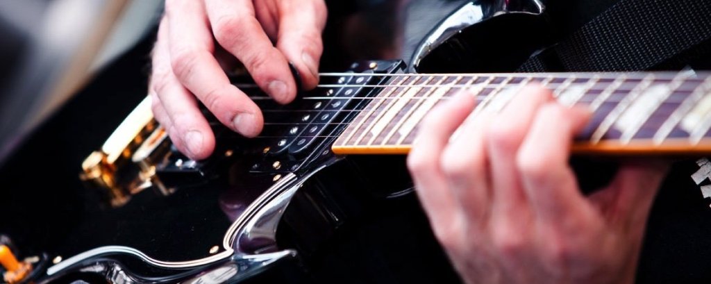 Guitar Teacher at Uncle Jon's Music closeup of hands playing guitar
